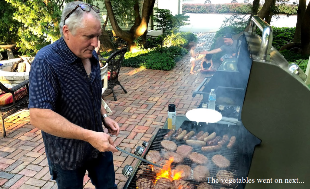 Bill Anderson, owner of Oswald's Pharmacy, cooking meat on the grill. He put veggies on next!