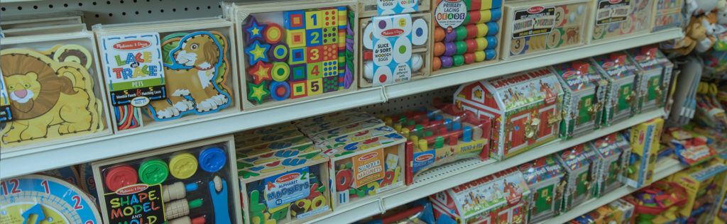 Picture of 2 shelves at Oswald's Pharmacy, stocked with painted Melissa&Doug wooden blocks.
