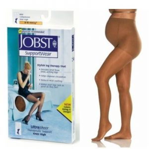 Jobst Ultrasheer Maternity hosiery. A pregnant model shows off a beige pair of maternity hosiery. Beige in color, the model stands next to the Jobst Ultrasheer box.