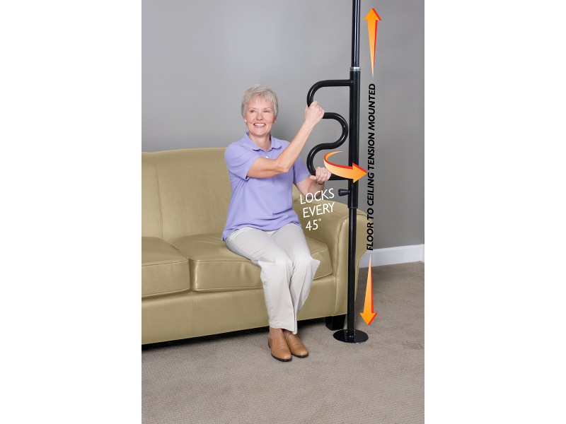Stander Security Pole, curved handle. An older woman grabs onto the curved part of the black security pole to get off of her couch.