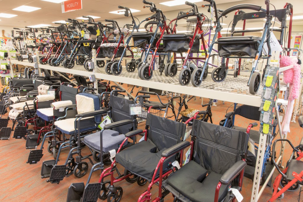 How to Rent a Wheelchair Featured image. A picture of the many wheelchair and transport chair options at Oswald's on the Medical Equipment Showroom floor. Rentals and purchases available. Rolling walkers can be seen on the top shelf, above the wheelchairs.