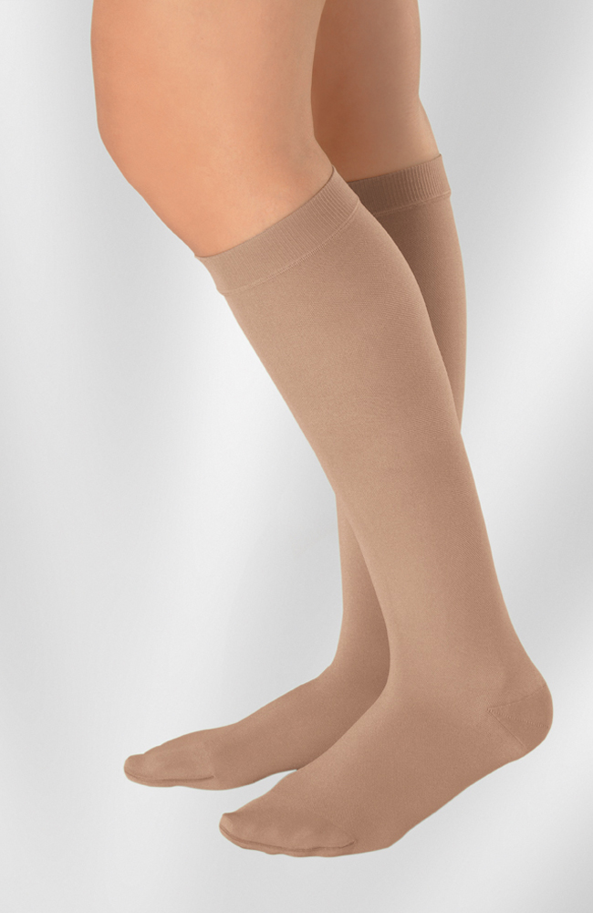 Juzo Compression Hosiery Stockings Soft Basic Casual Dynamic. A leg model wears a knee-high pair of beige Juzo socks.
