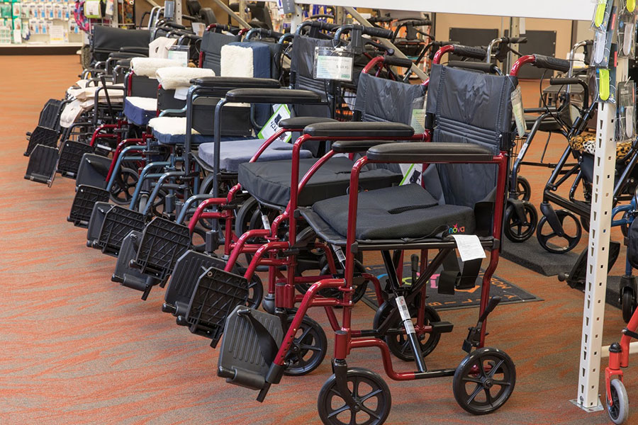 A row of red and blue (alternating) transport chairs available on the Oswald's Medical Showroom floor.