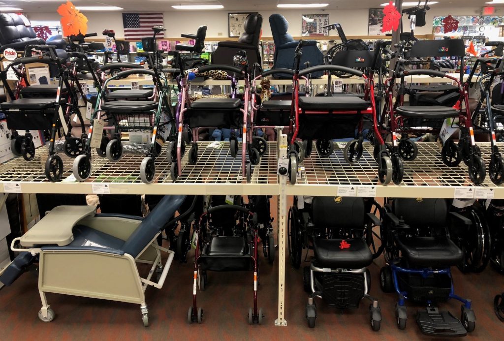 A small portion of the rolling walker or rollator stock on the Oswald's Pharmacy Medical Equipment Showroom Floor. A large shelving unit with 2 floors of rollators is pictured.