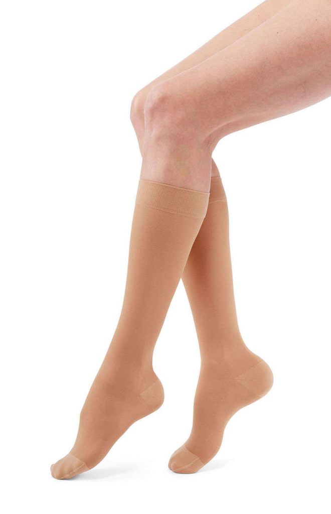 A female leg model wearing the mediven duomed transparent compression hosiery line in tan. Knee-high stylee.