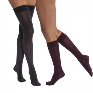 Jobst opaque compression stockings being worn by two leg models. The left set of legs belong to a woman and are thigh-high black. The legs on the right belong to a man and are in the knee-high style in black.