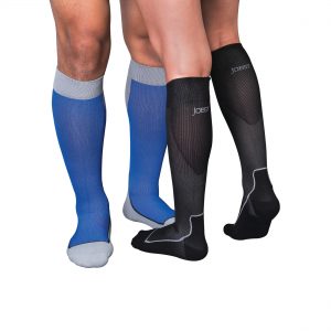Two leg models wearing Jobst compression sport socks. The left legs belong to a male and are in the knee-high style, blue in color with grey accents. The right set of legs belong to a woman and are in the knee-high style, black in color with grey accents.