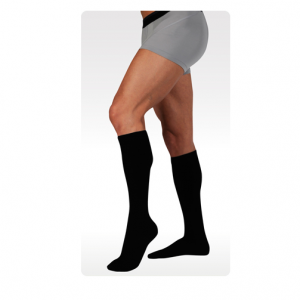 Juzo dynamic cotton compression socks being worn by a male leg model. Knee-high style in black.