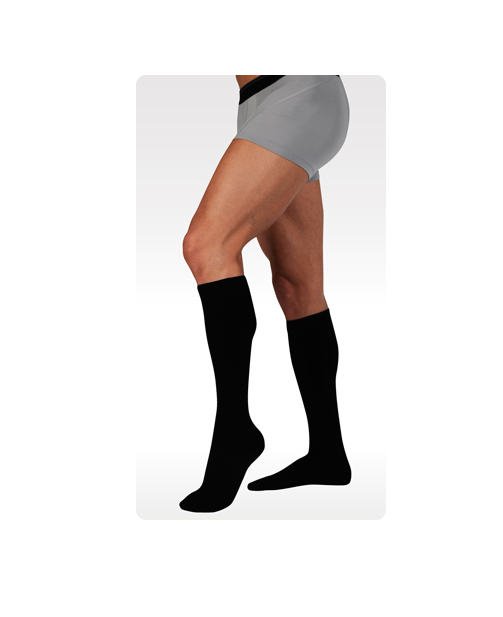Juzo dynamic cotton compression socks being worn by a male leg model. Knee-high style in black.