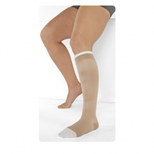 A Male leg model wearing Juzo Ulcer Pro wound care compression. The wrap is tan and is tightly wrapped around the man's leg, starting mid-foot and ending just below the knee.