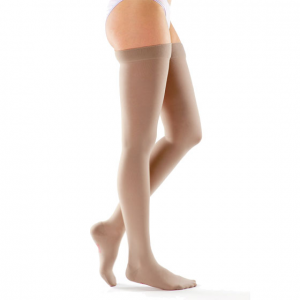 A female leg model wearing thigh-high Mediven plus compression hosiery in tan.