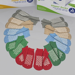 McKesson Slipper Socks product image. A semi circle of pairs of socks. From the top to bottom: XXL Grey, XL Beige, L Light Blue, M Green, S Red. All of the slipper socks have criss crossing slip resistant pads on the bottom.