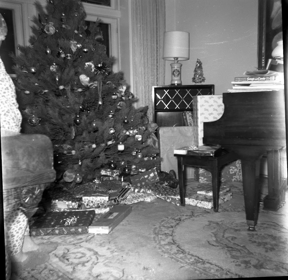 Message from Bill 2018 inset image--Oswald's Pharmacy owner Bill Anderson's home in 1967. Black and white picture of a Christmas tree with lots of gifts underneath.