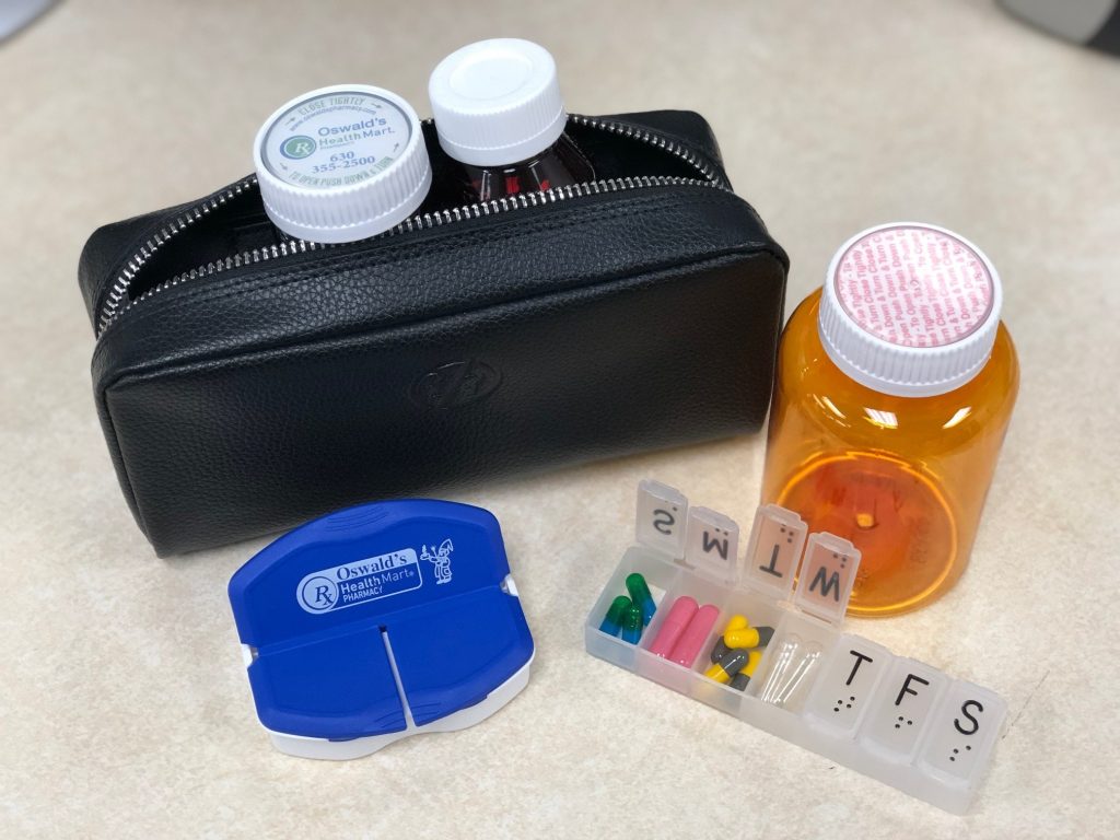 Medications on Vacation inset image. A picture of a travel bag with various pill containers around it.