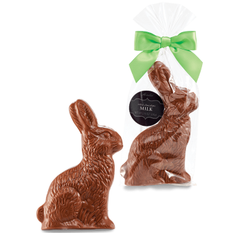 Image of an Abdallah milk chocolate Easter rabbit. Foreground is the standalone rabbit, background is the rabbit in a clear plastic package with a green bow.
