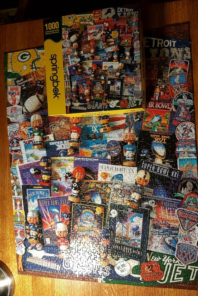 Springbok Super Bowl Puzzle. A completed puzzle showing images and memorabilia from the past 50 Super Bowls.