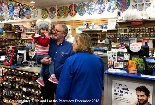 Picture of Bill Anderson and his granddaughter at the Oswald's Pharmacy post office counter.