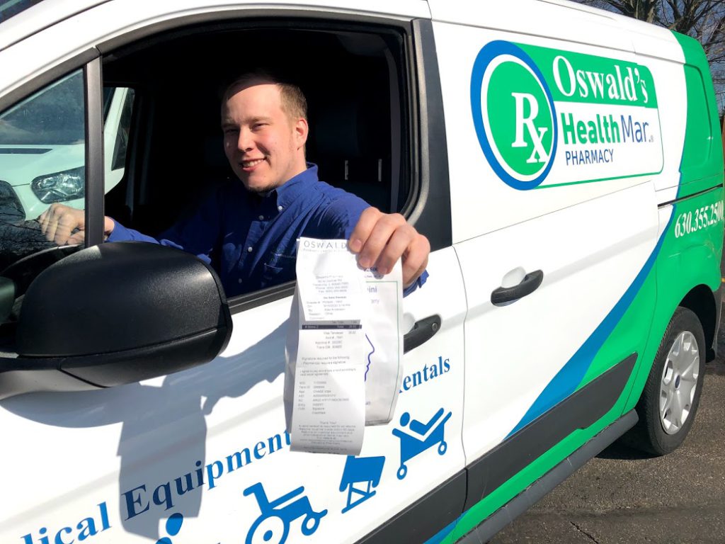 Picture of Oswald's Pharmacy team member Matias delivering a prescription in the Oswald's delivery van.