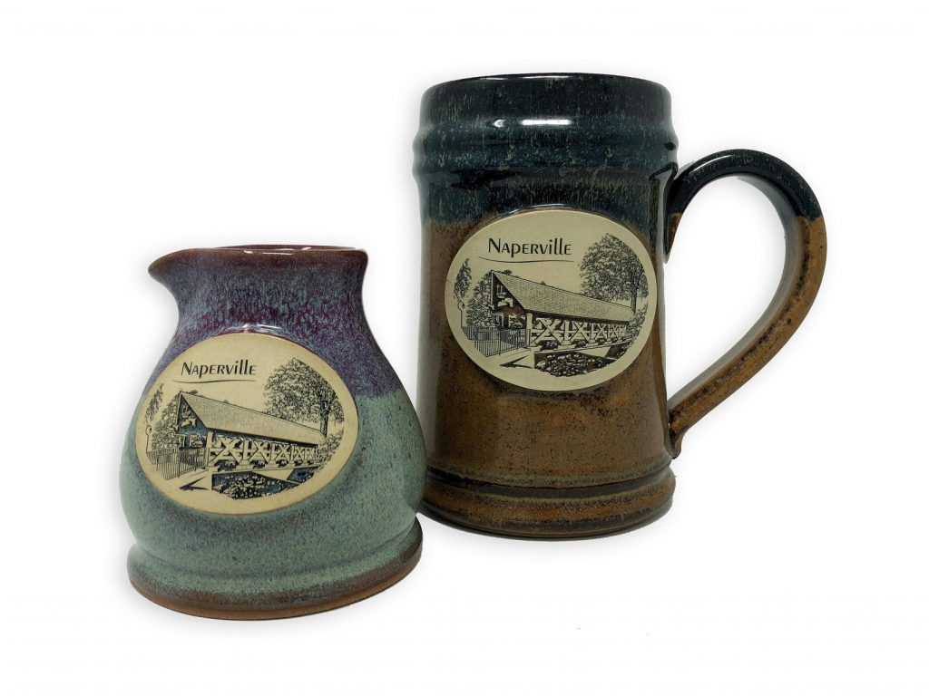 Naperville Stoneware Sunset Hill. Photo of two finished pieces of stoneware, featuring Naperville landmarks on one side.