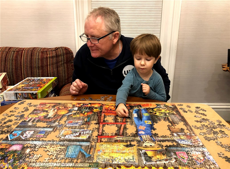Oswald's Puzzle blog image. Photo of Bill Anderson putting a jigsaw puzzle together with his grandson.