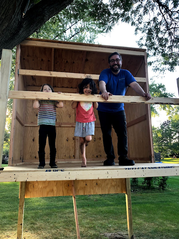 Photo of Alex and his kids standing on their new tree house.