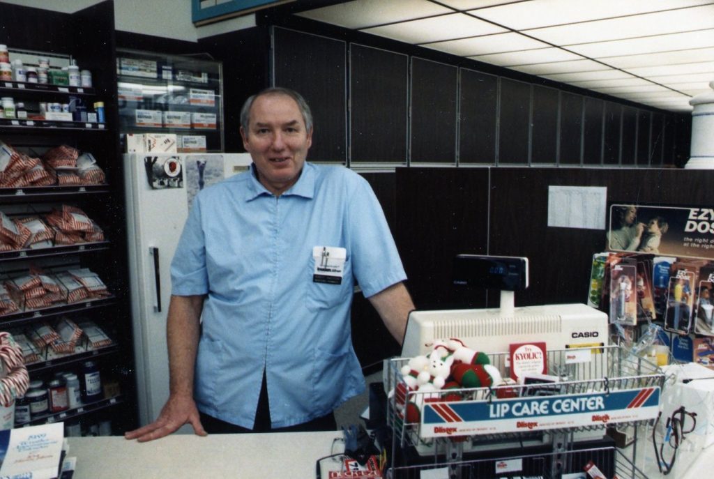 A photo of Bob Anderson working as the Pharmacist at Oswald's Pharmacy in 1988,