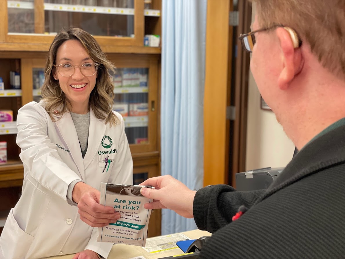 Oswald's Pharmacy Transfer Prescriptions image 1. Photo of a pharmacist greeting a customer.