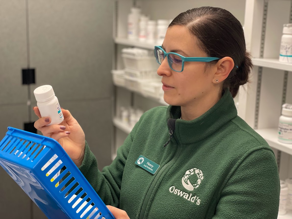 Oswald's Pharmacy Transfer Prescriptions image 2. Photo of a pharmacy technician checking a new prescription.