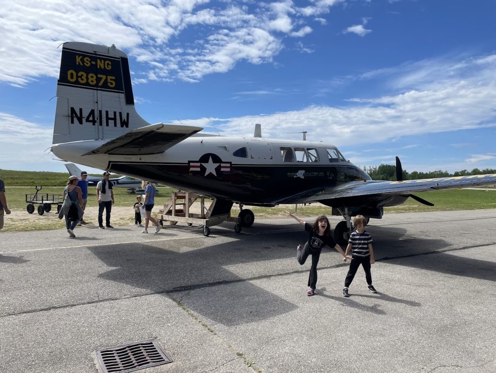 A Message From Alex August 2024. Image of kids ready to board a small plane.