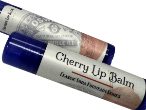 Two tubes of Oswald’s Cherry Lip Balm from the Classic Soda Fountain Series, featuring vintage-style labels and blue caps.