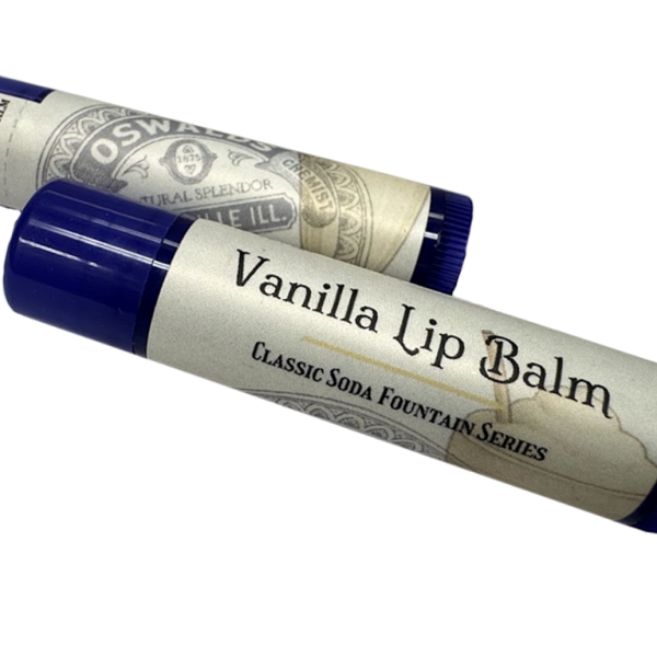 Two tubes of Oswald’s Vanilla Lip Balm with vintage-style labels and dark blue caps, part of the Classic Soda Fountain Series.